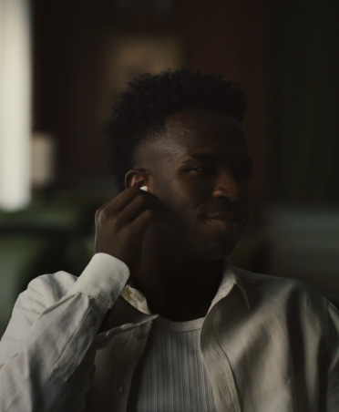 AirPods Pro 3, person in white shirt pinching right earbud