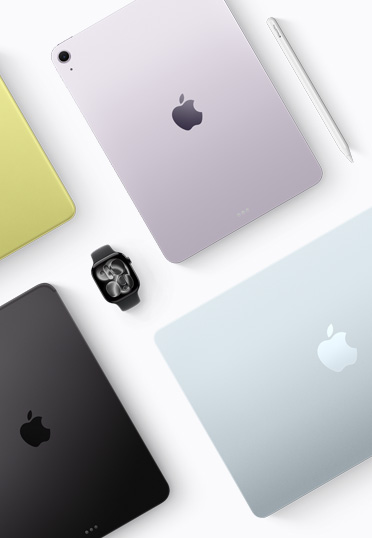 Forskellige Mac- og iPad-modeller i flere farver vist oppefra med et sort Apple Watch i midten.
